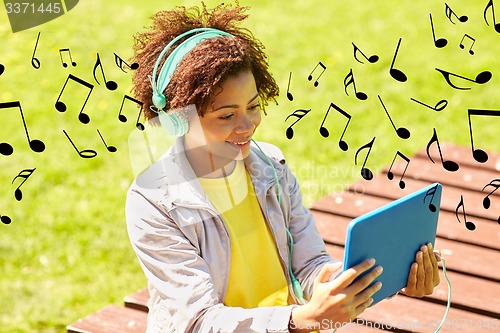 Image of happy african woman in headphones with tablet pc