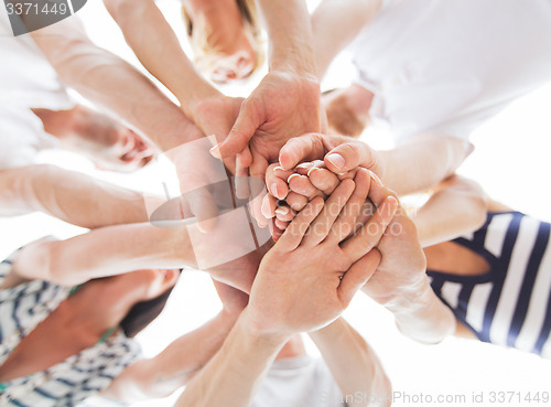 Image of close up of friends with hands on top