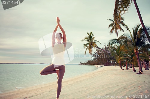 Image of young woman making yoga exercises outdoors