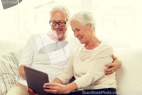 Image of happy senior couple with tablet pc at home