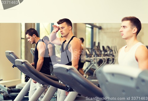 Image of group of men exercising on treadmill in gym