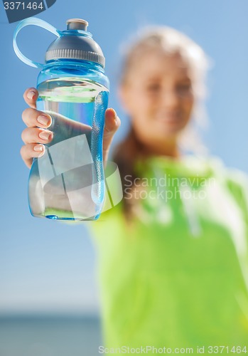 Image of woman showing a bottle of water