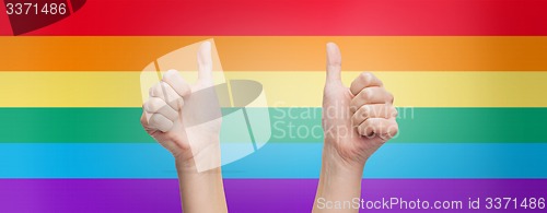 Image of hands showing thumbs up over rainbow background