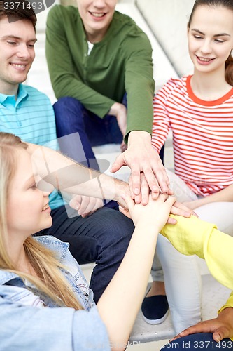 Image of close up of students or friends with hands on top