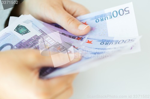 Image of close up of woman hands counting euro money