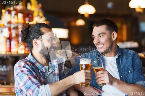 Image of happy male friends drinking beer at bar or pub