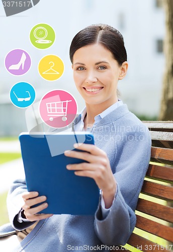 Image of smiling business woman with tablet pc in city