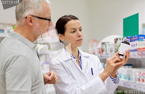 Image of pharmacist showing drug to senior man at pharmacy