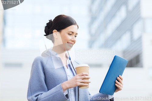 Image of smiling business woman with tablet pc in city