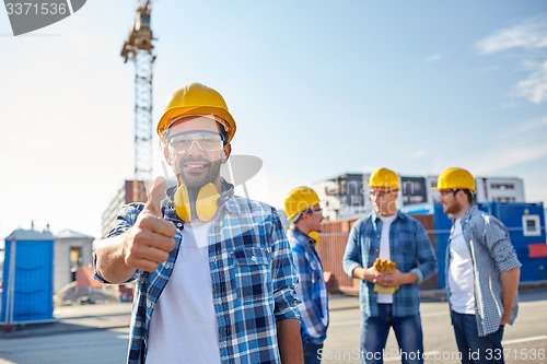 Image of builders showing thumbs up at construction site