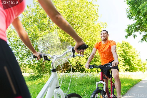 Image of close up of happy couple riding bicycle outdoors