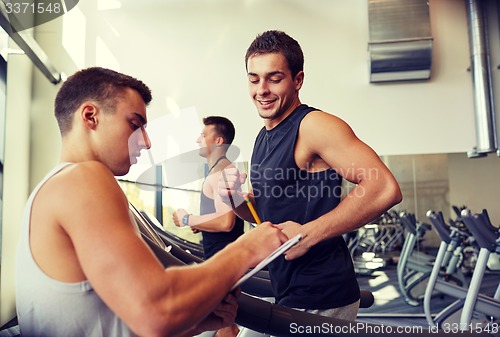 Image of men exercising on treadmill in gym