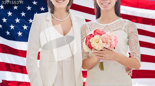 Image of close up of happy lesbian couple with flowers