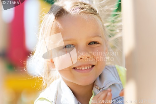 Image of happy little girl climbing on children playground