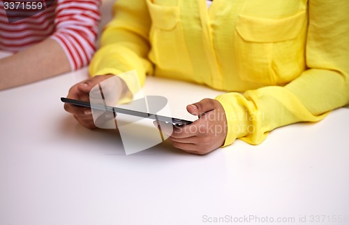 Image of close up of female hands with tablet pc at table