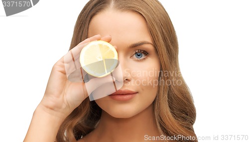 Image of beautiful woman face with lemon slice over eye