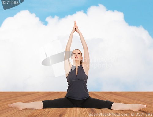 Image of happy young woman doing yoga exercise