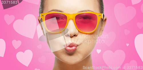 Image of girl in pink sunglasses blowing kiss