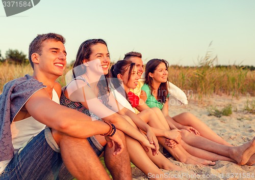 Image of smiling friends in sunglasses on summer beach