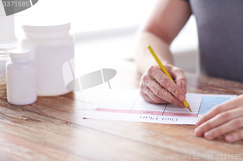 Image of close up of man with protein jars and diet plan