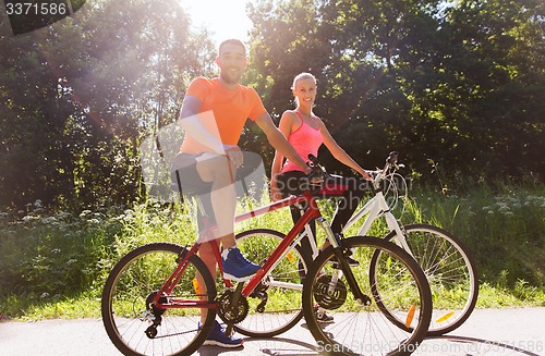 Image of happy couple riding bicycle outdoors