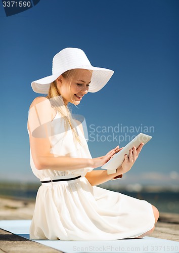 Image of beautiful woman in a dress with tablet pc