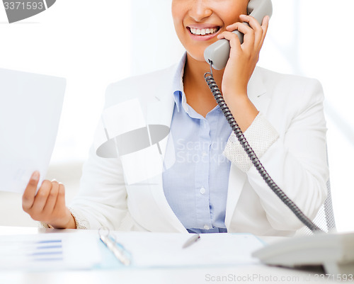 Image of african businesswoman with phone in office