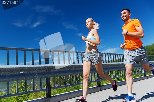 Image of smiling couple running at summer seaside