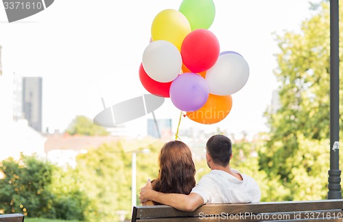 Image of happy couple with air balloons in city