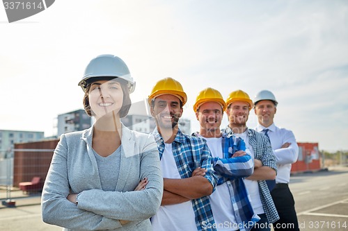 Image of happy builders and architect at construction site