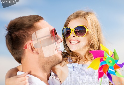 Image of happy father and child in sunglasses over blue sky