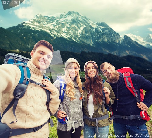 Image of group of smiling friends with backpacks hiking