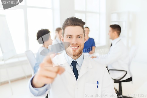 Image of happy doctor over group of medics at hospital