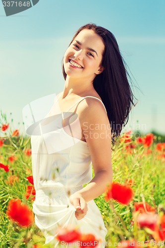 Image of smiling young woman on poppy field