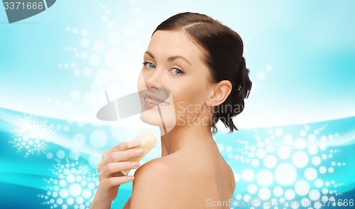 Image of woman with soap bar over blue wavy background