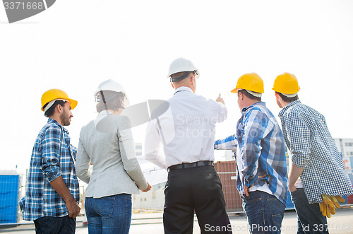 Image of group of builders and architects at building site