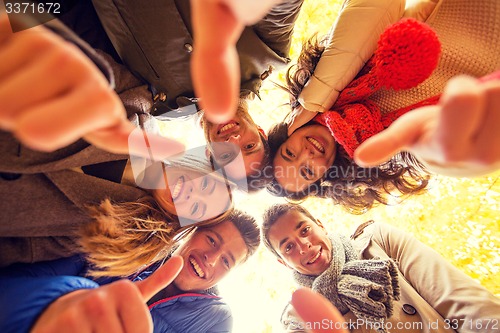 Image of group of smiling men and women in autumn park