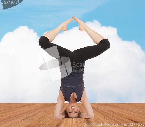 Image of happy young woman doing yoga exercise