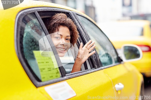 Image of happy african american woman driving in taxi