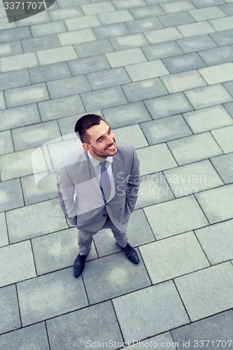 Image of young smiling businessman outdoors from top