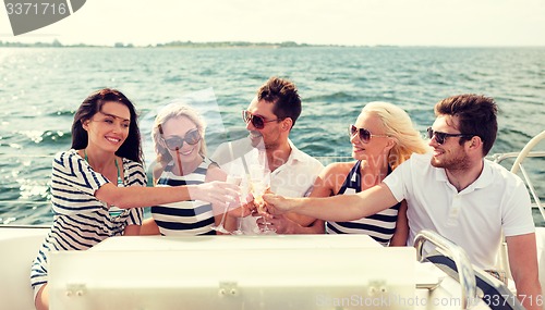 Image of smiling friends with glasses of champagne on yacht