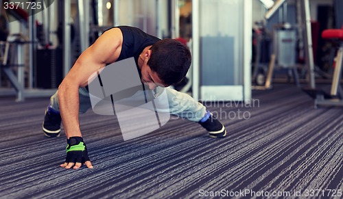 Image of man one arm push-ups in gym