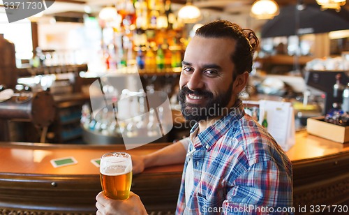 Image of happy man drinking beer at bar or pub