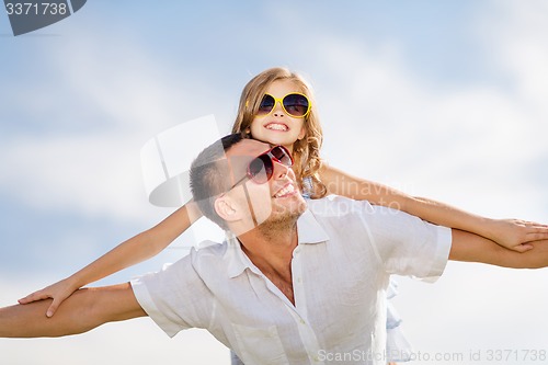 Image of happy father and child in sunglasses over blue sky