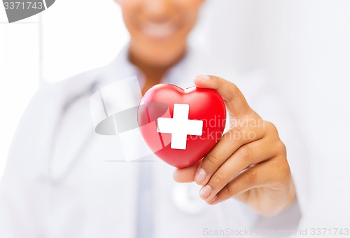 Image of female doctor holding heart with red cross symbol