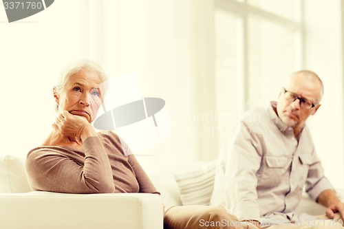 Image of senior couple sitting on sofa at home