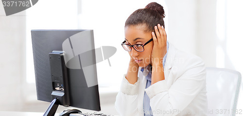 Image of stressed african woman with computer