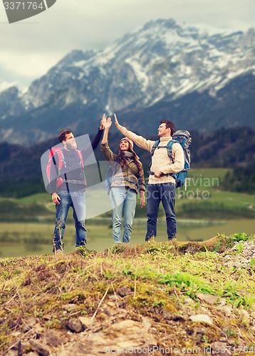 Image of group of smiling friends with backpacks hiking