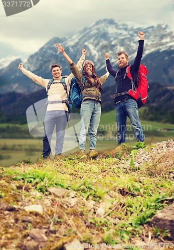 Image of group of smiling friends with backpacks hiking