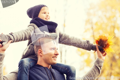 Image of happy family having fun in autumn park